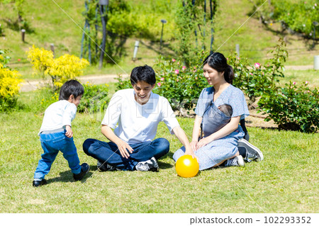 Child playing ball with family in park Child playing ball with family in park 102293352