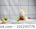 Trendy authentic dirty soda cocktail with cola, lime juice and cream in the kitchen table 102293776