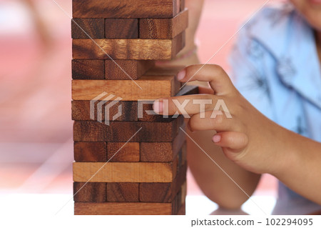 Wooden puzzle game align vertically and finger of child in toy concept. 102294095