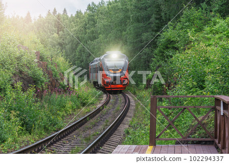 Passenger train approaches to the wooden platform. Passenger train approaches to the wooden platform. 102294337