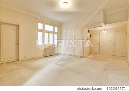 an empty room with white walls and light fixtures on the ceiling in front of the door to the other rooms an empty room with white walls and light fixtures on the ceiling in front of the door to the other rooms 102294571