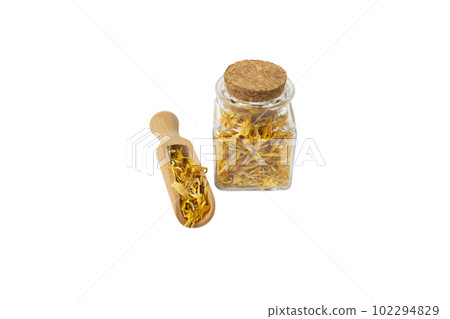 Dried Calendula or Marigold petals in wooden scoop and glass jar isolated on white background. 102294829