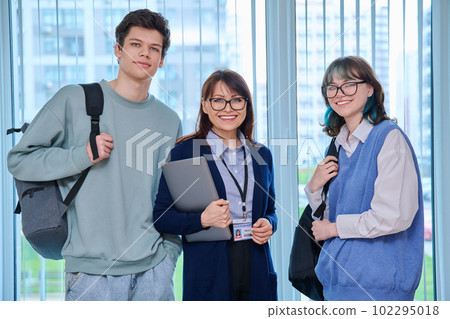 Portrait of female teacher, guy and girl, college students looking at camera 102295018