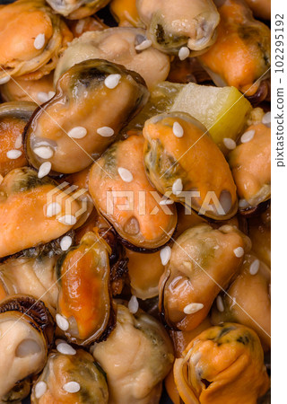 Delicious marinated mussels with spices and herbs on a ceramic plate 102295192