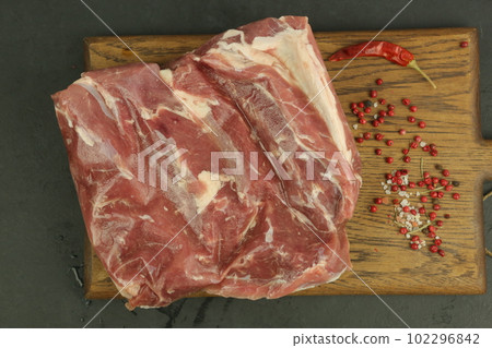 frosted big peace of beef meat closeup photo on kitchen board 102296842