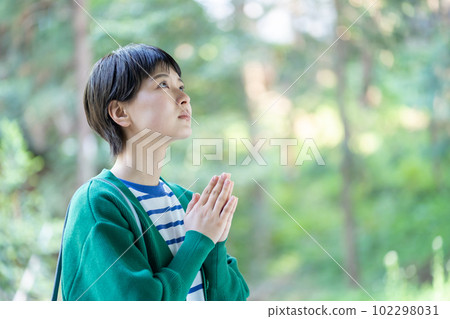 A woman praying, a woman making a wish, praying, praying, visiting a power spot, a shrine 102298031