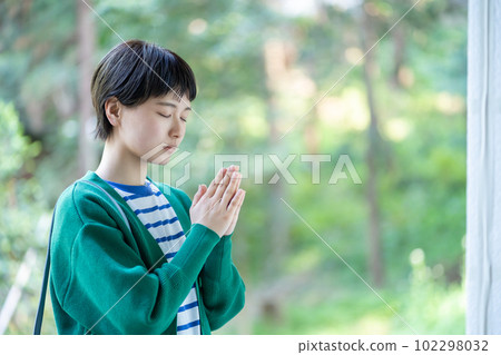 A woman praying, a woman making a wish, praying, praying, visiting a power spot, a shrine 102298032