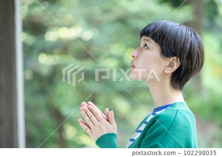 A woman praying, a woman making a wish, praying, praying, visiting a power spot, a shrine A woman praying, a woman making a wish, praying, praying, visiting a power spot, a shrine 102298035
