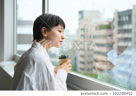 Woman looking out of the window Woman looking out of the window 102298402