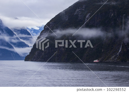 cruising boat beside mountain at milfordsound fiordland national park southland new zealand 102298552