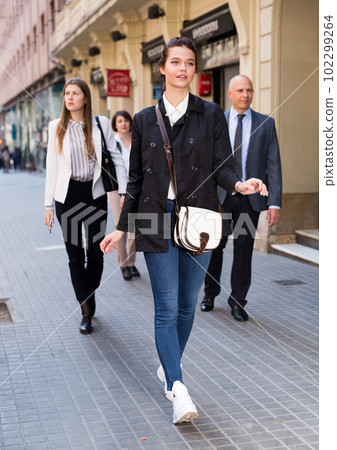 Young woman walking on street 102299264