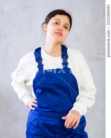 Positive young woman cleaning service worker in blue uniform Positive young woman cleaning service worker in blue uniform 102299495