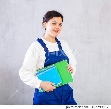 Positive female cleaning service worker with order books 102299507