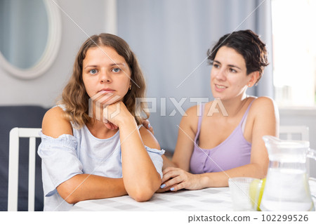 Beautiful girl with dark hair keep arms folded, do not talk to her friend Beautiful girl with dark hair keep arms folded, do not talk to her friend 102299526