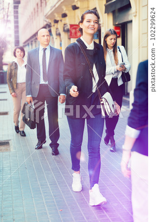 People in formal wear walking down street in city 102299624