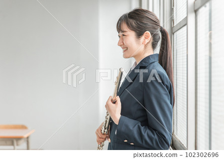 Asian high school girl practicing flute in school extracurricular activity 102302696