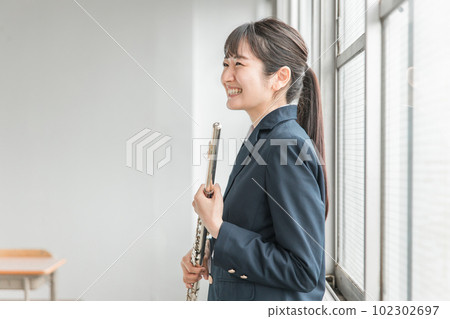 Asian high school girl practicing flute in school extracurricular activity 102302697