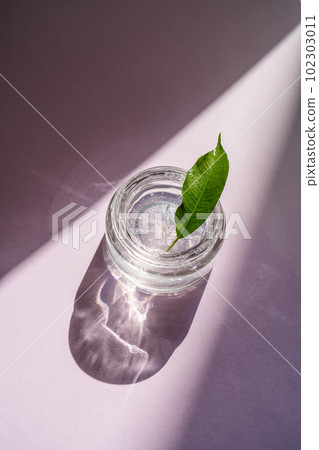 Transparent gel in a jar on a lilac background. 102303011