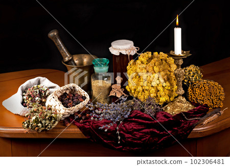 Dried healing herbs, flowers and candles, ritual purification , copyspace Close up of healing herbs alchemist stuff. Old pharmacy, alternative medicine concept. mortar and pestle. on a black 102306481