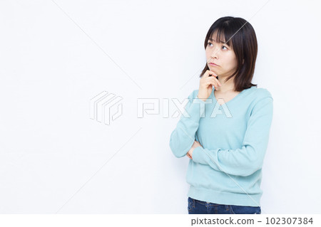 一個三十多歲的女人，在白人背景前嚴重擔心 102307384