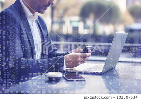 Businessman working outdoors using a PC and smartphone Businessman working outdoors using a PC and smartphone 102307534