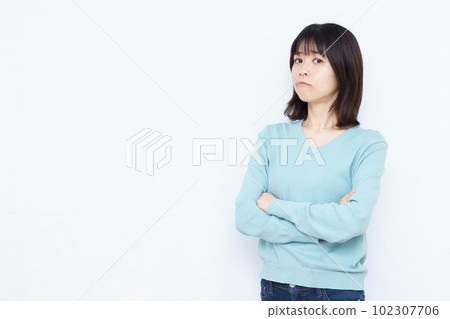 一個三十多歲的女人在白色背景前雙手交叉憤怒 一個三十多歲的女人在白色背景前雙手交叉憤怒 102307706