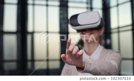 Office employee having fun at work, watching 3D video in virtual reality glasses Office employee having fun at work, watching 3D video in virtual reality glasses 102307810