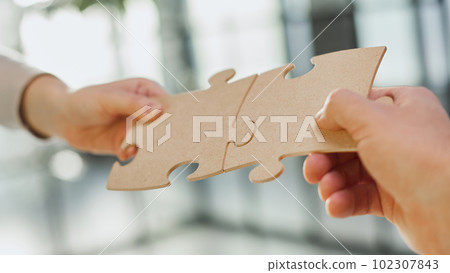 close up of business people connecting couple puzzle jigsaw, business solution concept. 102307843