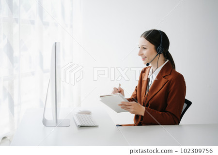 Serious call center operator in wireless headset talking with customer, woman in headphones with microphone consulting client on phone in customer support service in office center.. 102309756