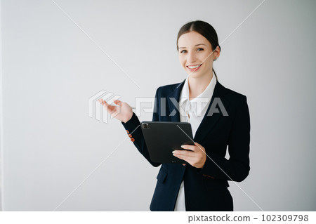 Smiling caucasian young businesswoman bank employee worker manager boss ceo looking at camera, using tablet, laptop and notepad online isolated in white background. Smiling caucasian young businesswoman bank employee worker manager boss ceo looking at camera, using tablet, laptop and notepad online isolated in white background. 102309798