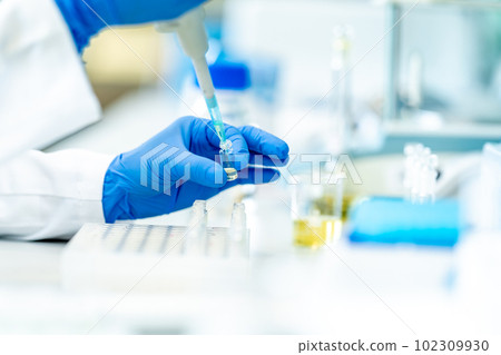 pipetting of chemical samples during research in a biochemical scientific laboratory pipetting of chemical samples during research in a biochemical scientific laboratory 102309930