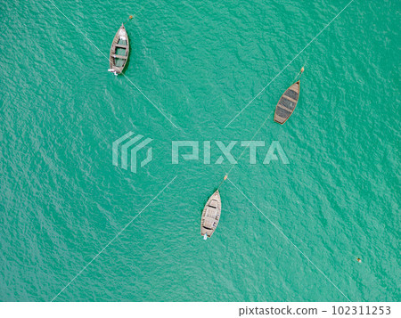 A stunning view of a wooden boat on the lake surrounded by the lush green landscape from a top view perspective. 102311253