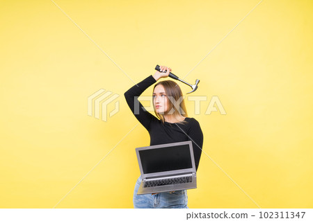 Laptop Repair. Female with hammer and laptop on yellow background 102311347