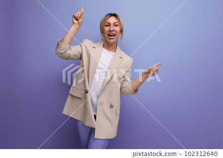 charming blonde young adult in jacket smiling on studio background 102312640