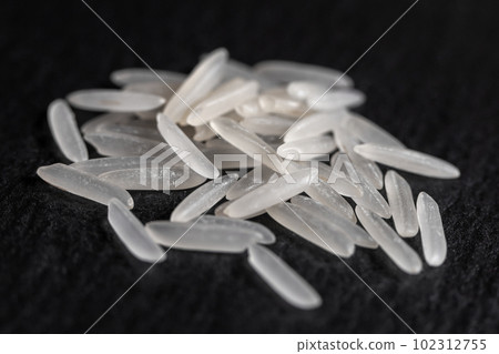 White rice on a black graphite stone slab White rice on a black graphite stone slab 102312755