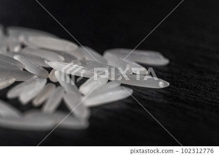 White rice on a black graphite stone slab 102312776