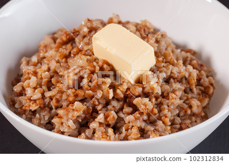 buckwheat porridge with butter in white plate. Food 102312834