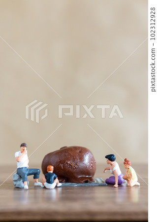 Miniature people Happy family enjoying chocolate Miniature people Happy family enjoying chocolate 102312928