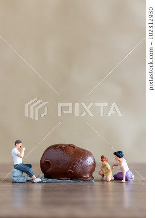 Miniature people Happy family enjoying chocolate 102312930