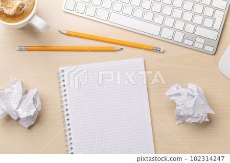 Top view of blank notepad, keyboard, coffee and crumpled papers 102314247