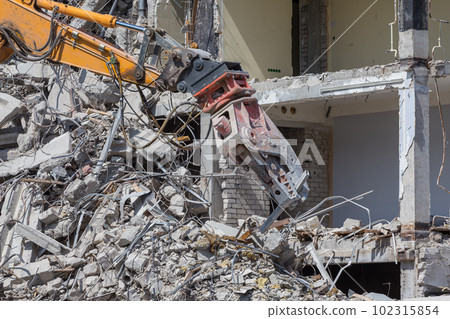 Demolition crane dismantling a building 102315854