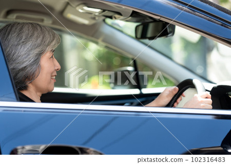 Senior woman driving a car 102316483