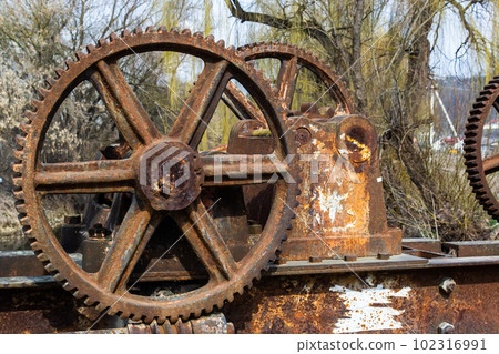 old mechanical metal gears mechanism on the abandoned dam old mechanical metal gears mechanism on the abandoned dam 102316991