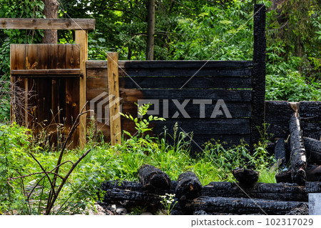 Destroyed by fire wooden house completely burned to the ground .ruins of a burnt wooden house after a fire 102317029