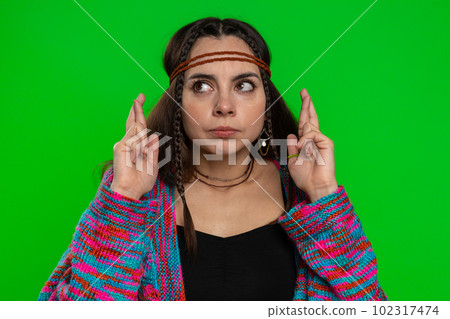 Young woman crossed fingers looking at camera asking for good luck news dreaming about win victory 102317474