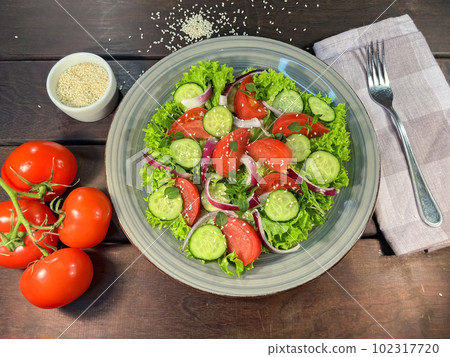 Salad of fresh tomatoes and cucumbers in a bowl 102317720