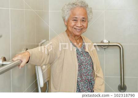 Asian elderly old woman patient use toilet support rail in bathroom, handrail safety grab bar, security in nursing hospital. Asian elderly old woman patient use toilet support rail in bathroom, handrail safety grab bar, security in nursing hospital. 102318790