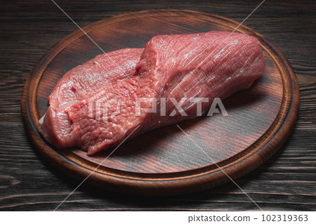 Fresh raw meat on dark cutting board Fresh raw meat on dark cutting board 102319363