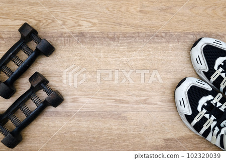 Expander dumbbells and running shoes. Fitness, sports. Place for text Expander dumbbells and running shoes. Fitness, sports. Place for text 102320039
