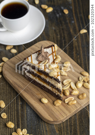 a piece of chocolate cake with caramel and peanuts a piece of chocolate cake with caramel and peanuts 102320344